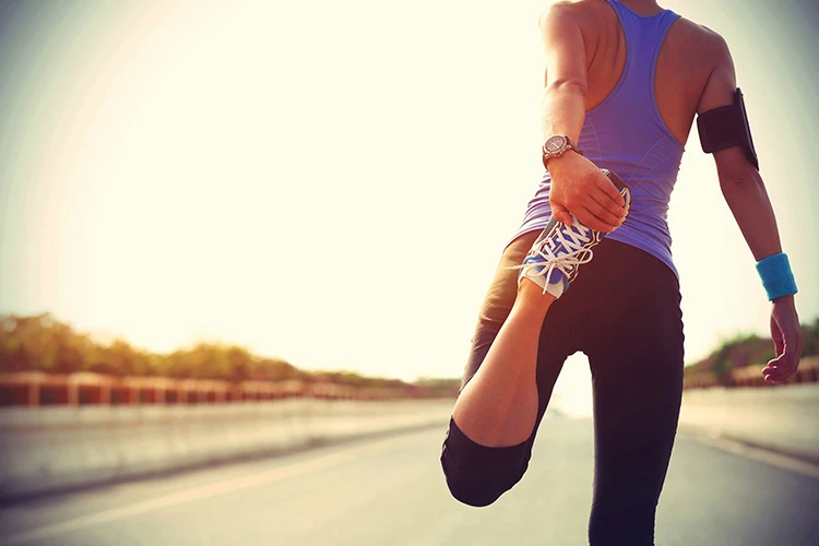 sporty woman stretching leg outdoor