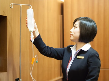 uniformed woman holding a IV bag